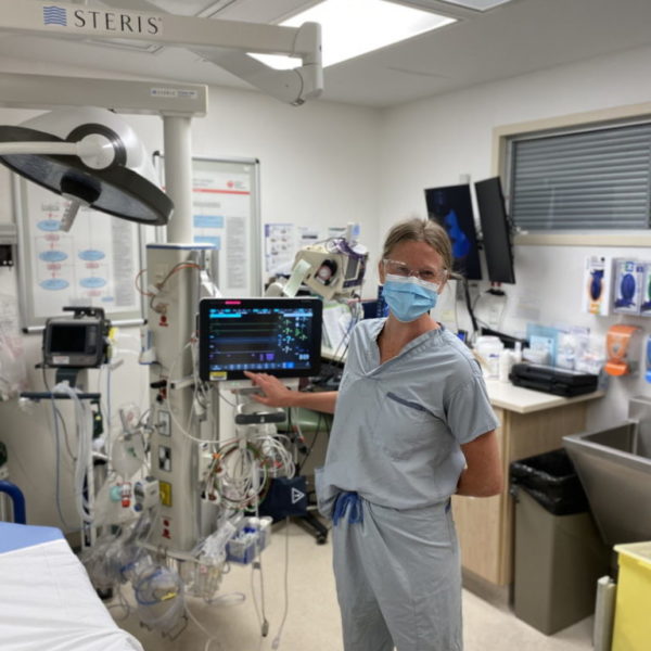 International nursing student stands proudly in front of medical device