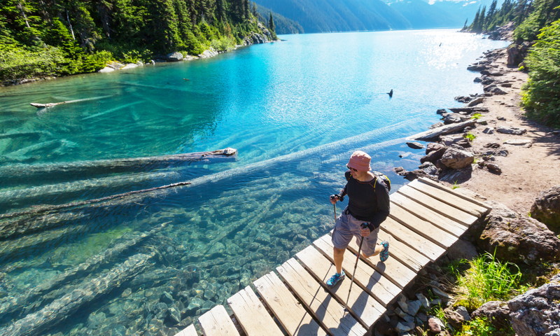 man hiking across a lake